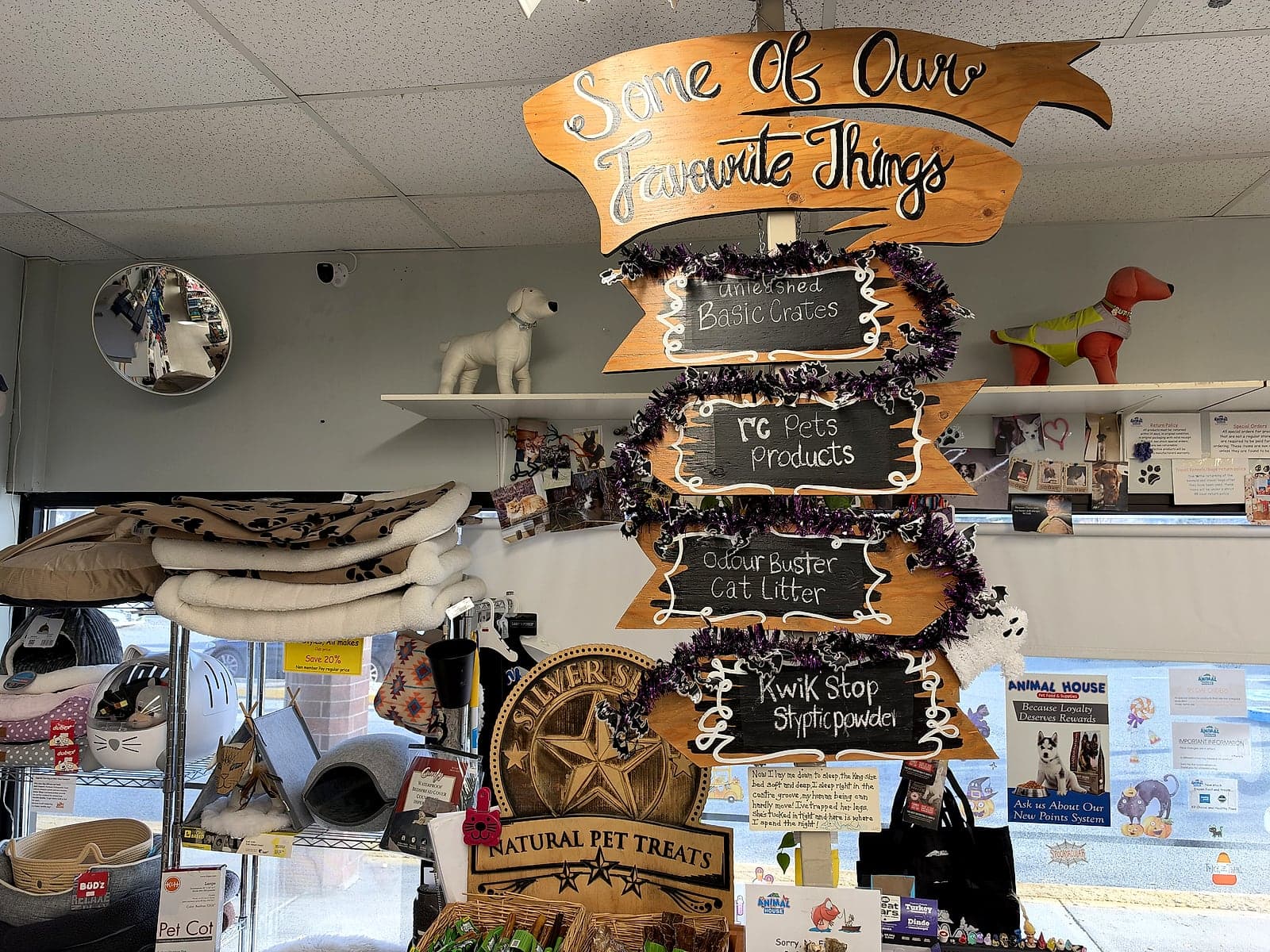 A wooden signpost reading Some of our favourite things above the counter, pointing to treats and products