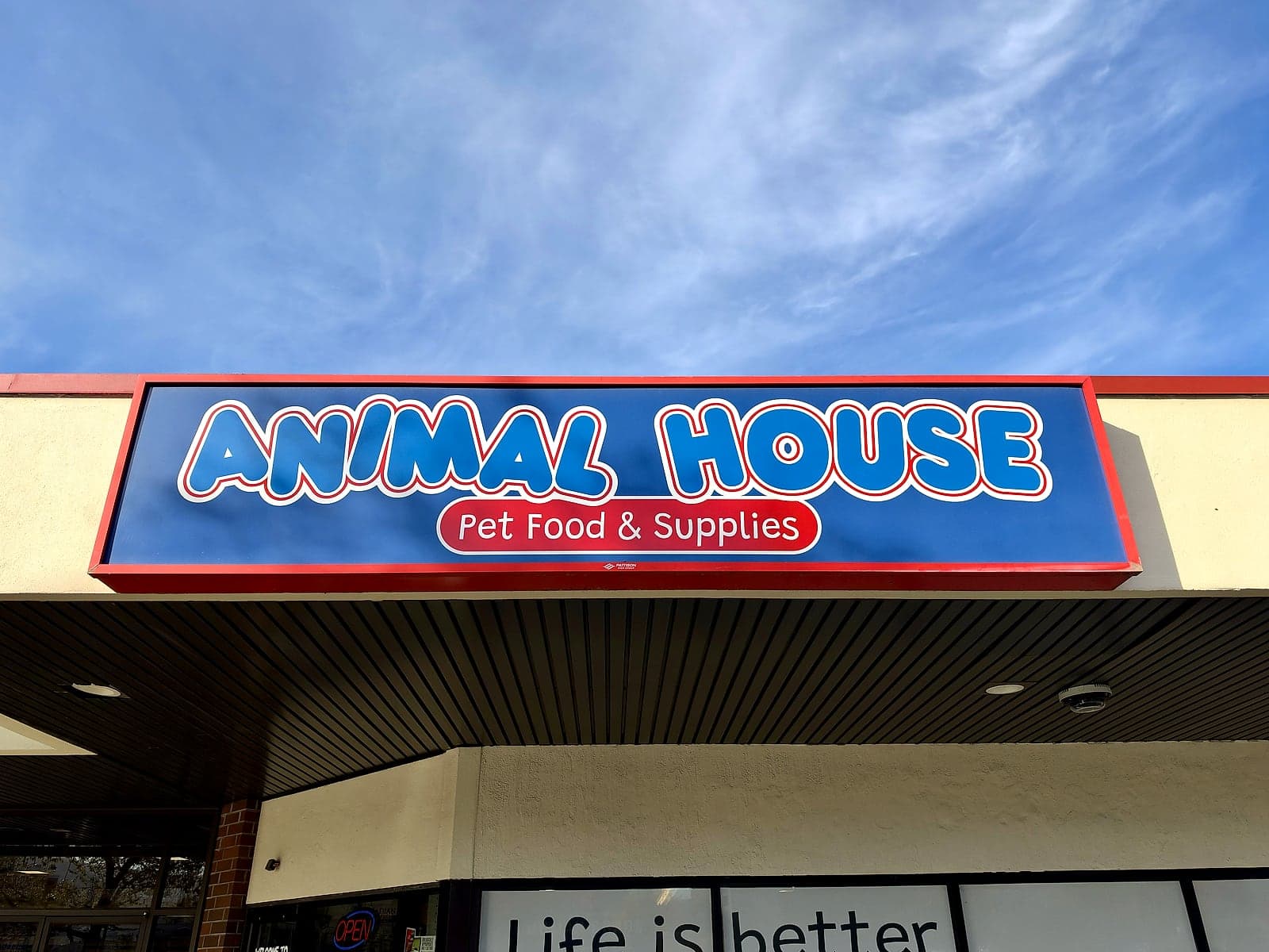 The red and blue Animal House Pet Food & Supplies sign above the storefront, under a blue sky