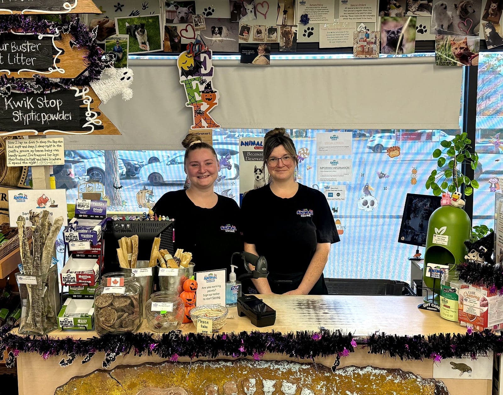 Two Animal House staff members smiling behind the front counter