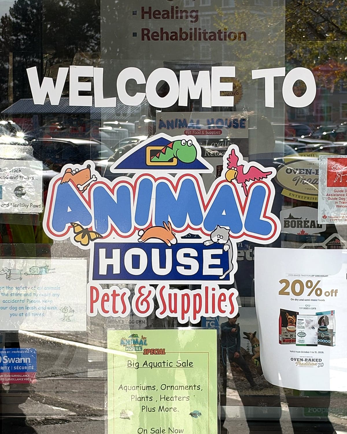 A Welcome to Animal House Pets & Supplies decal with the cartoon animal logo on the glass front door
